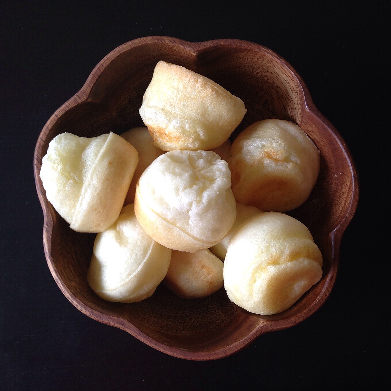 Pães de queijo dourados em uma cesta